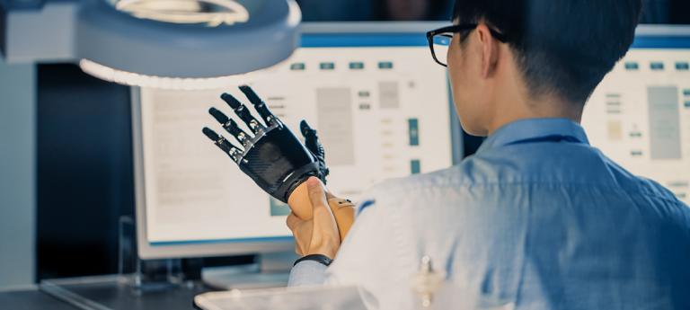 Close Up of a Futuristic Prosthetic Robot Arm Being Tested by a Professional Japanese Development Engineer in a High Tech Research Laboratory with Modern Computer Equipment