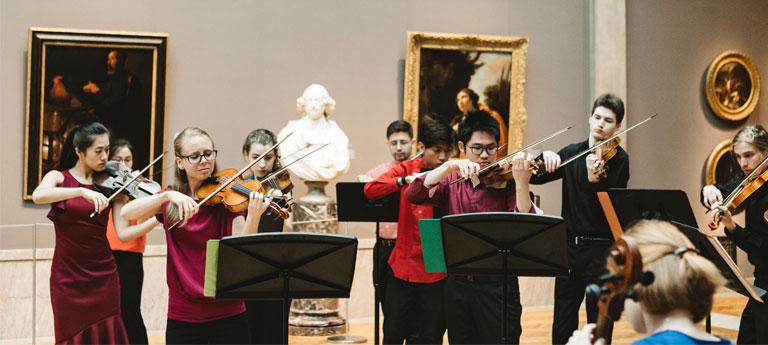 A group of CWRU students playing strings instruments at Cleveland Museum of Art