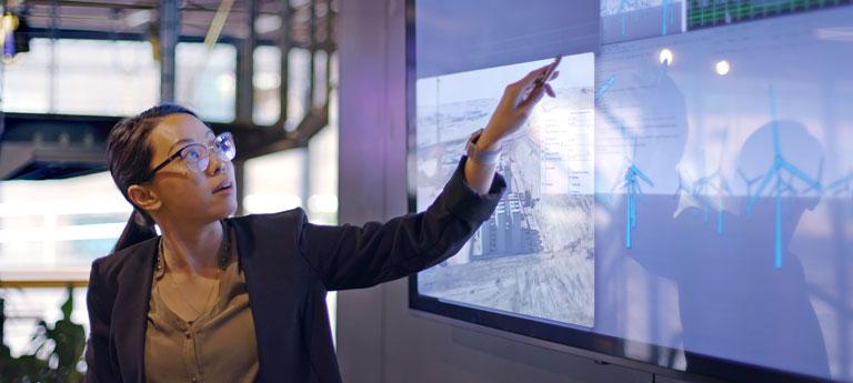 Photo of a person standing in front of an interactive whiteboard