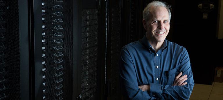 Case Western Reserve University Professor Jonathan Haines poses next to machines