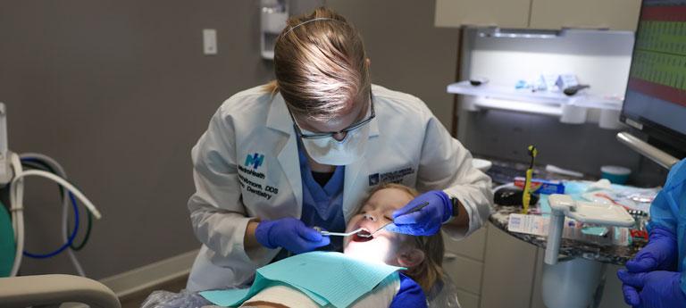 A Case Western Reserve University School of Dental Medicine resident provides care to a pediatric patient