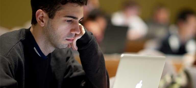 A Weatherhead School of Management student looks at a laptop screen while in a classroom