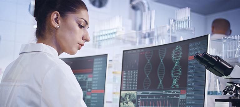  A female researcher views DNA data and biological analysis results on a computer monitor in a lab.