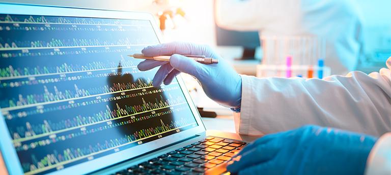  Close-up of a scientist in blue gloves pointing at a DNA sequencing graph on a laptop screen in a lab.