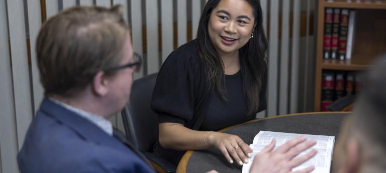 two people at a table with a law book