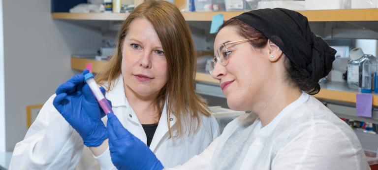 A student and professor looking at a sample together in a lab