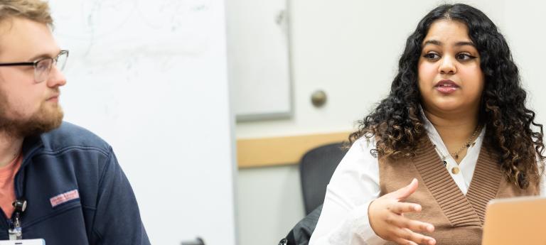Two bioethics students discussing in a classroom