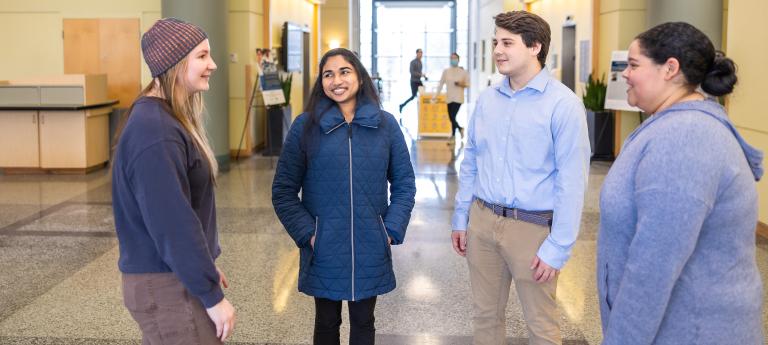 Four bioethics students talking in a hallway