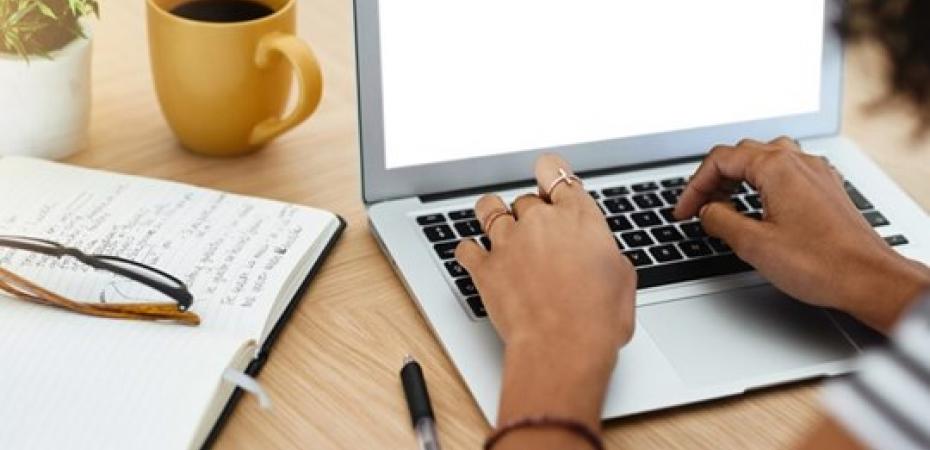 Photo of hands typing on a computer keypad