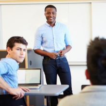 A professor standing at the front of a classroom.