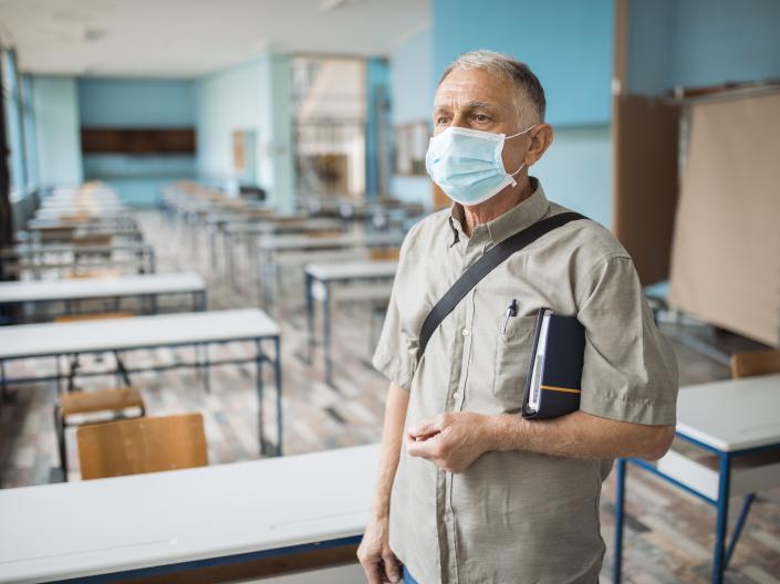 Man wearing a mask in a classroom.