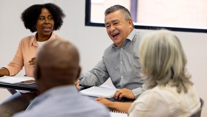 Faculty sitting at a table talking.