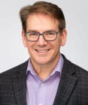 Male with glasses and dark sport jacket