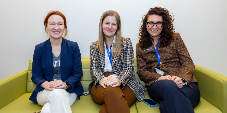 A group pf women sitting a sofa smiling.