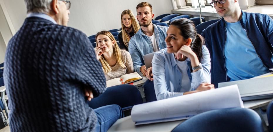 A group of students talking civilly with a teacher.