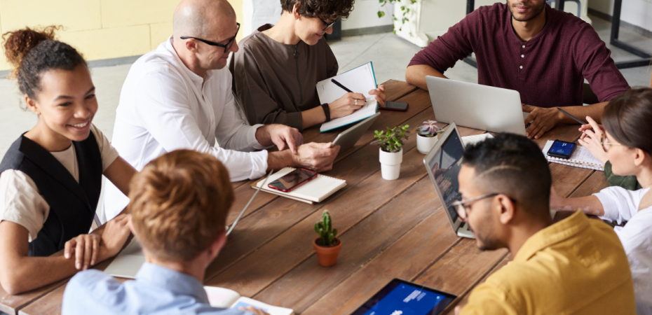 Group of people planning around the table with paper and computers
