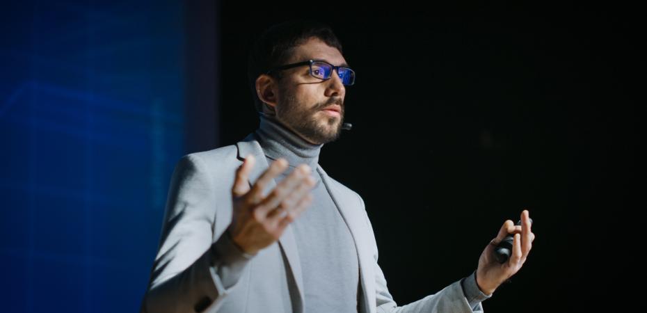 A person standing on stage pitching an idea.