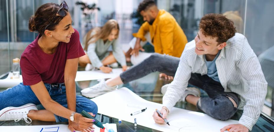 A group of students sitting making signs