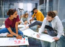 A group of students sitting making signs