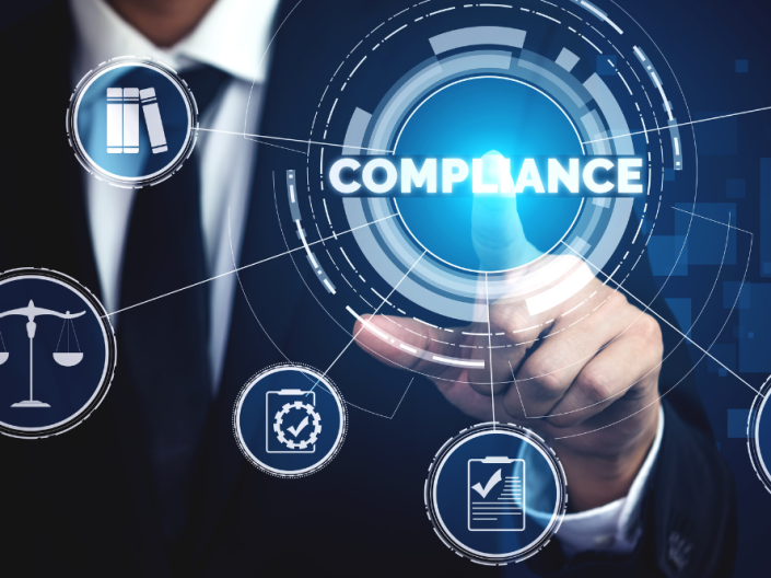 A man's finger pointing to the word "compliance"