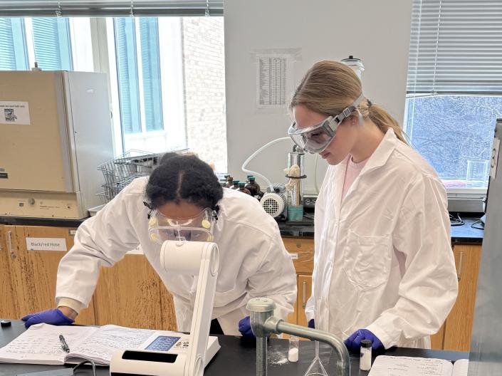 Students looking through a microscope.