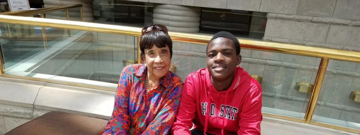 Dr. Faye Gary and Provost Scholar sitting on a bench at the museum