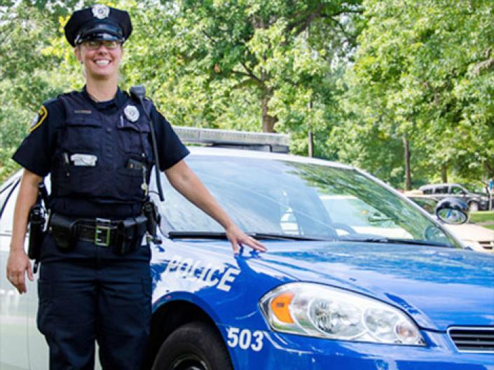 Female officer standing by patrol vehicle