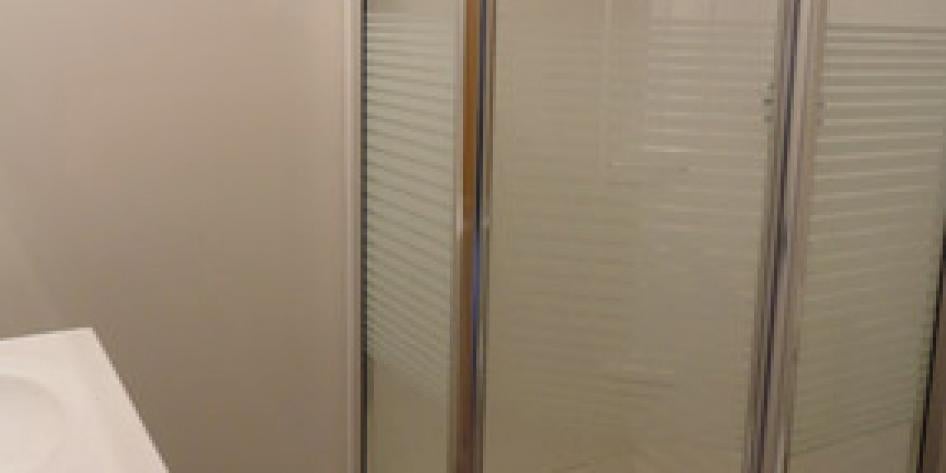 White bathroom with wraparound shower