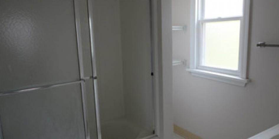 White bathroom with shower and bright window
