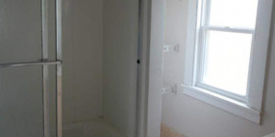 White bathroom with shower and bright window