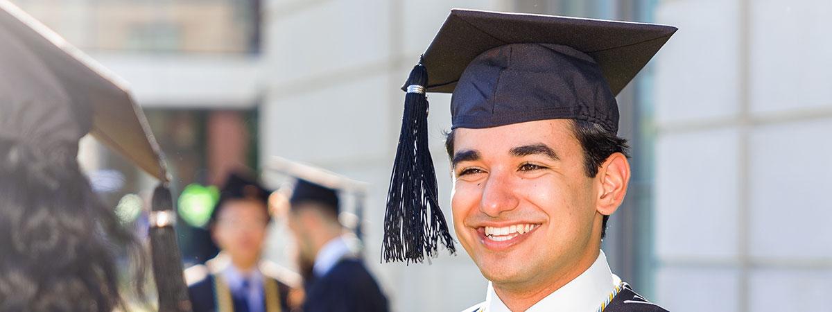 Graduate with cap on smiling.