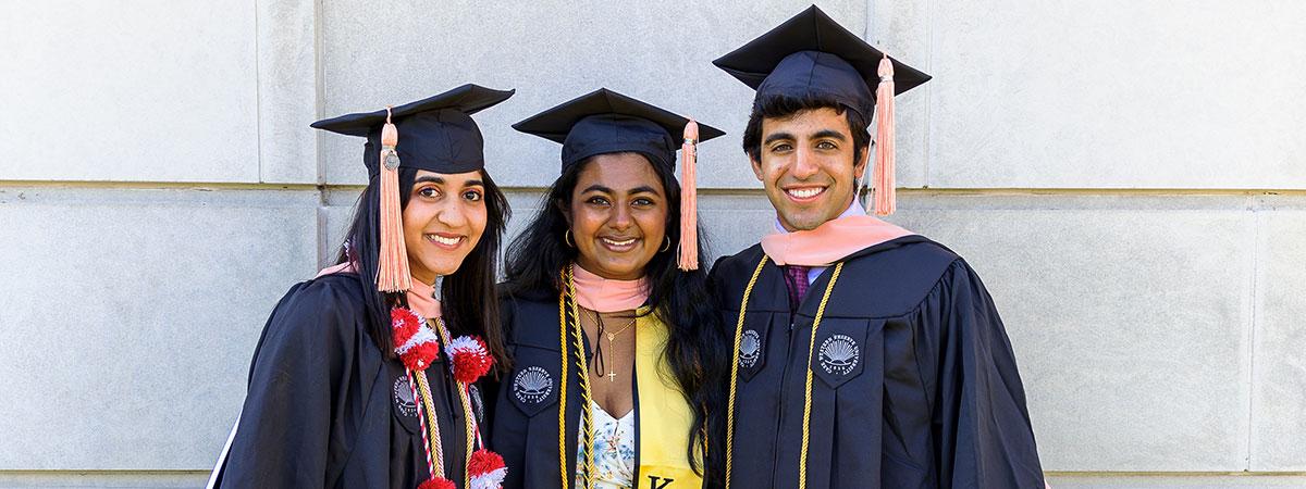 Three graduates in their caps and gowns.