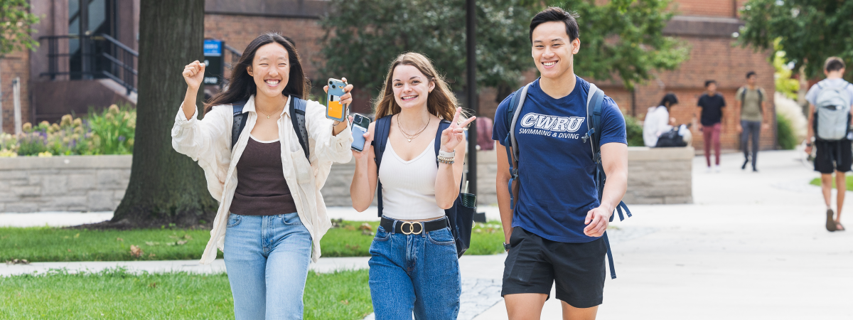 Three students walking on the quad.