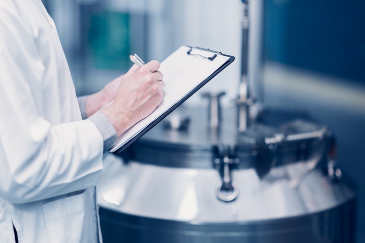 medicine science factory staff worker check quality products sterilize in autoclave tank in check list.