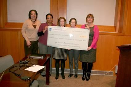 Members of the Case Western Reserve University Staff Advisory Council and representatives from Family Promise holding a check