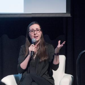 Cara Byrne seated on stage speaking to audience