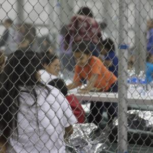 Photograph of detained immigrant children at the U.S. border behind chain link fence