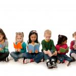 Group of young children from different races sitting on the floor and reading books