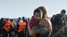 Photograph from the cover of Violent Borders - a young refugee child held in his mother's arm after perilous sea journey on a raft
