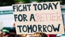 Person holding poster that says 'Fight Today for a Better Tomorrow'