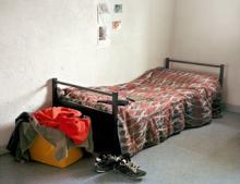 Photograph from Prison Nation exhibit depicting a stark bedroom scene