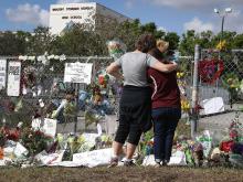 Photograph of mourners outside Marjory Stoneman Douglas High School in Parkland Florida following the shooting