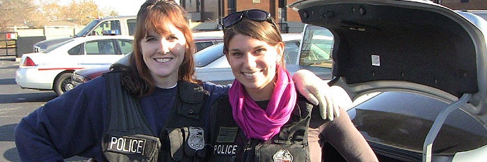 Two female police officers facing the camera smiling