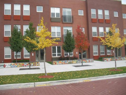 New red brick apartment building, trees in front with fall leaves