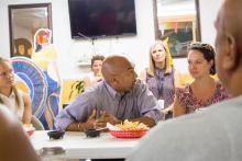 Mark Jospeh and Amy Khare sitting at a table speaking with a small group of people