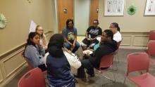 Group of people from many races sitting together in a circle talking