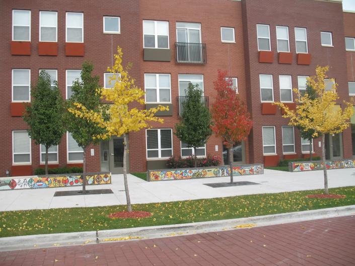 New red brick apartment building, trees in front with fall leaves