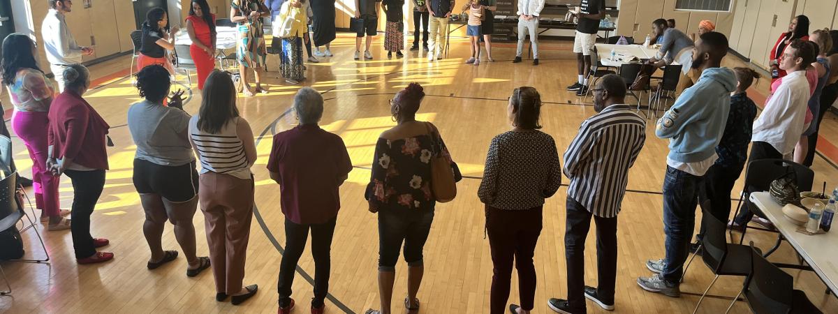 Picture of a circle of people in a big room