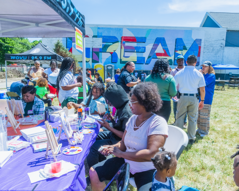 Group of people sitting in front of a truck with the word Dream