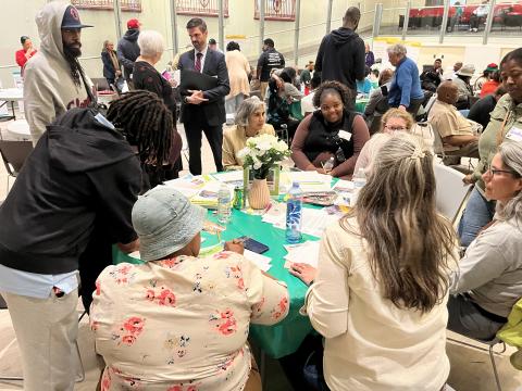 A group of people sitting around a table having a discussion